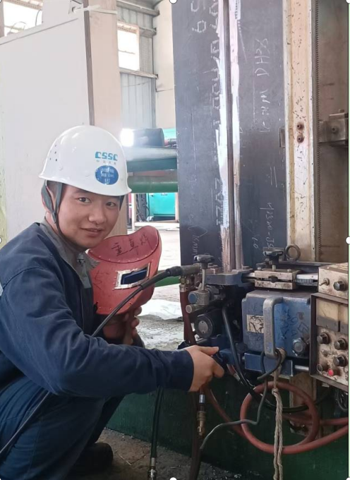 谢祖靠在调试电焊设备