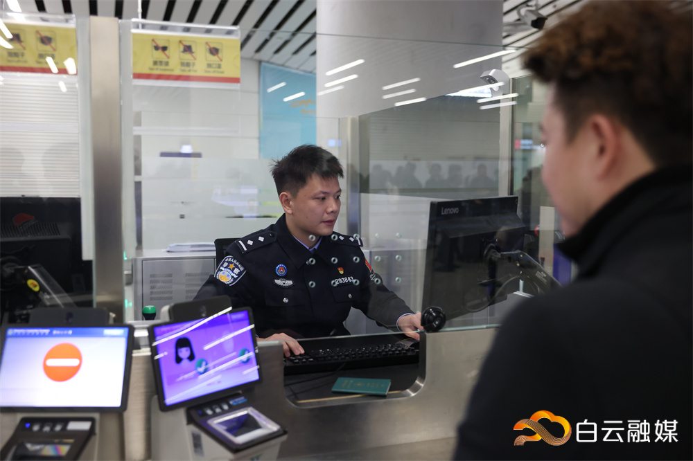 图为民警庄德祥为旅客办理入境边检手续
