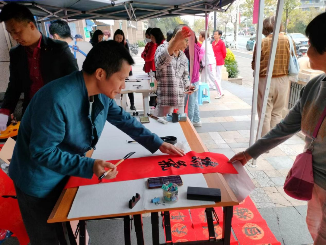 (图:社区知名书法家挥毫泼墨,为居民写春联、送福字)