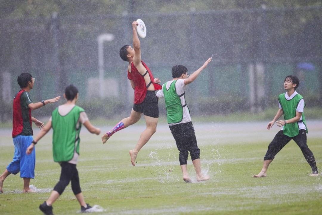 学员们在雨中快乐玩飞盘。