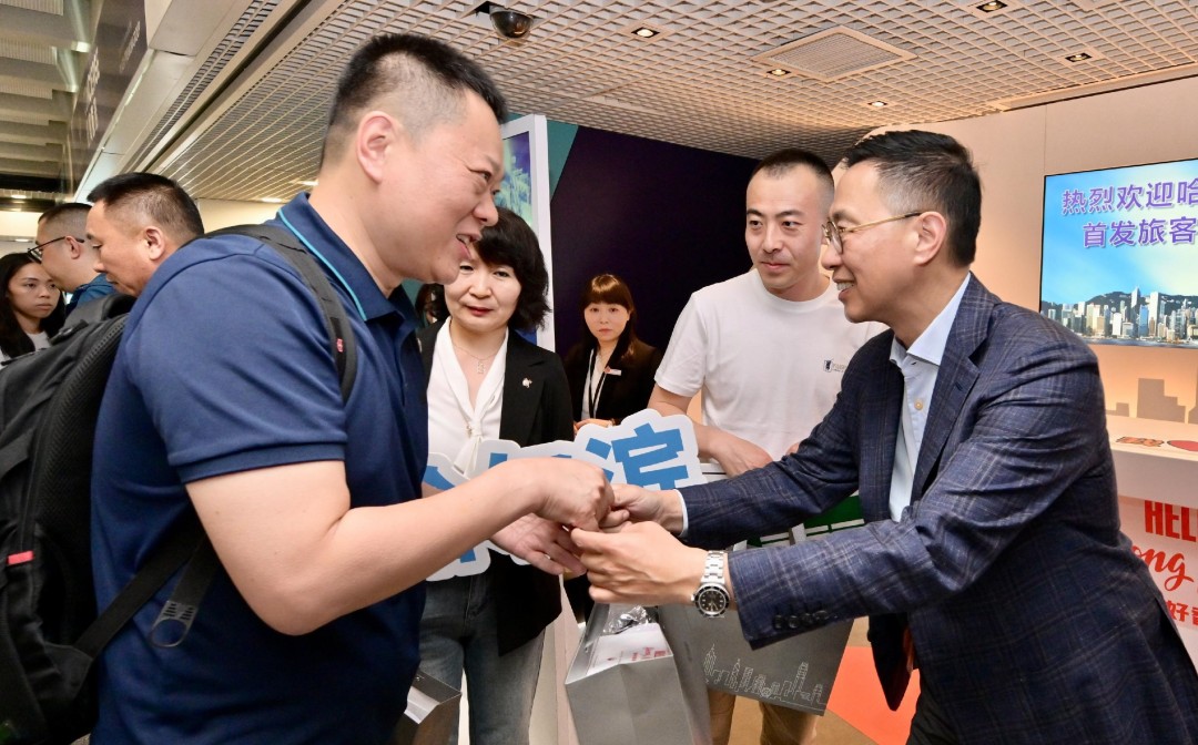 楊潤雄(右一)迎接來自內地城市的旅遊業界代表並贈送紀念品,展現香港對他們的熱烈歡迎。
