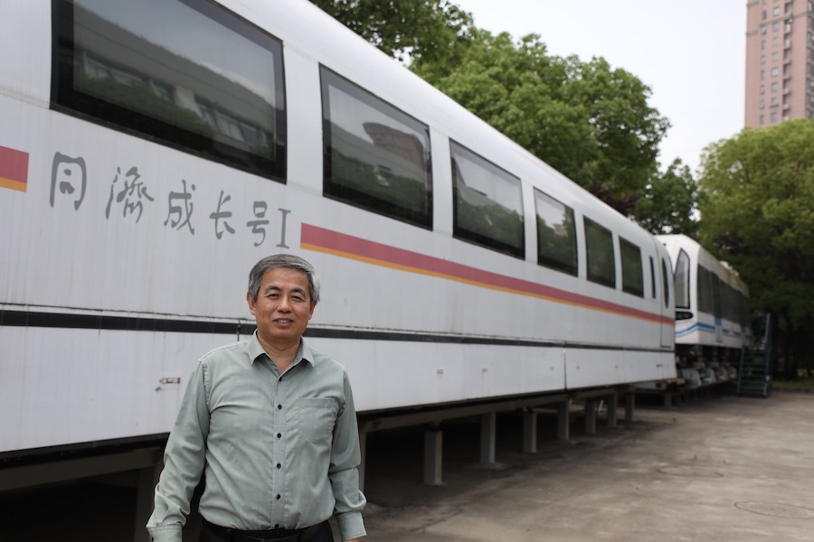 林国斌教授与身后的高速磁浮列车、中低速磁浮列车2