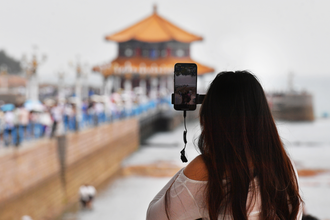 一位网络博主在某景区直播避暑人流。(视觉中国).jpg 一位网络博主在某景区直播避暑人流。(视觉中国).jpg