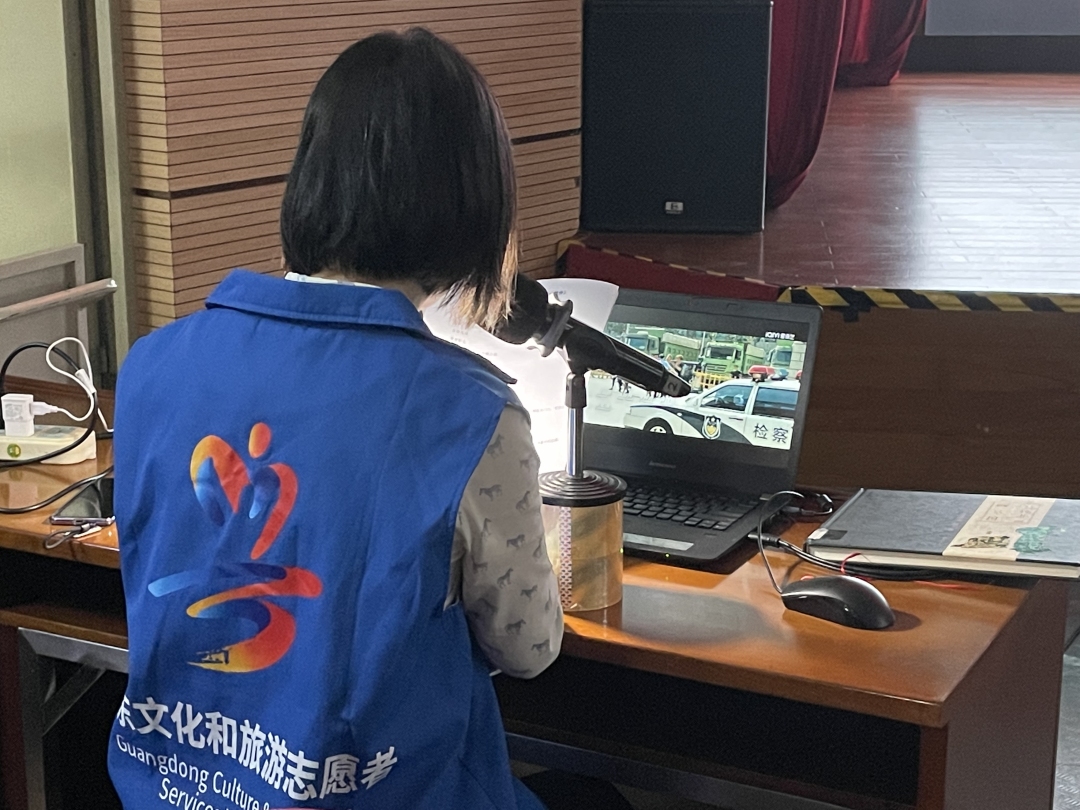 口述志愿者一边对着屏幕一边对着讲稿