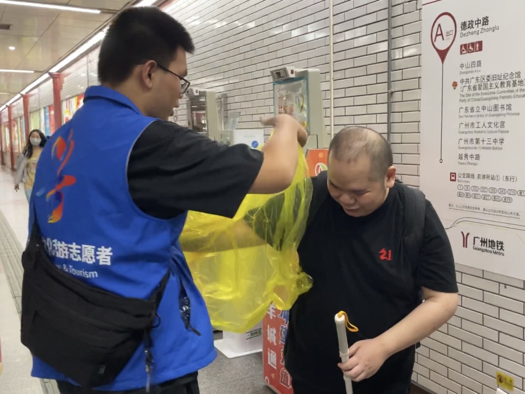活动当天下雨,志愿者给李嘉文套上雨衣