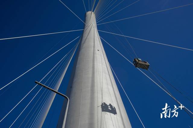 清晨的项目现场,工人通过施工钢索随桥塔升向空中作业。 清晨的项目现场,工人通过施工钢索随桥塔升向空中作业。