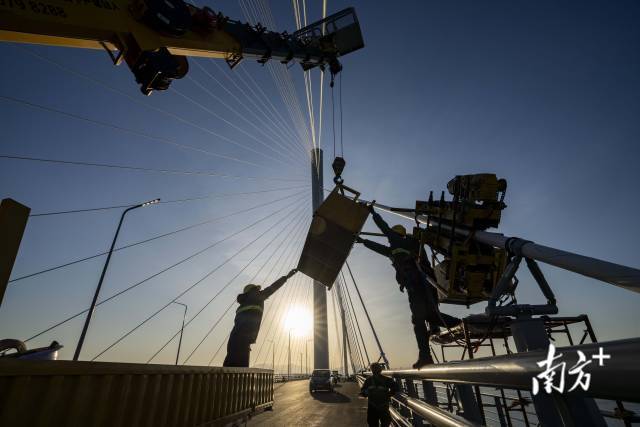 工人迎着朝阳在路面进行最后收尾施工工作。 工人迎着朝阳在路面进行最后收尾施工工作。