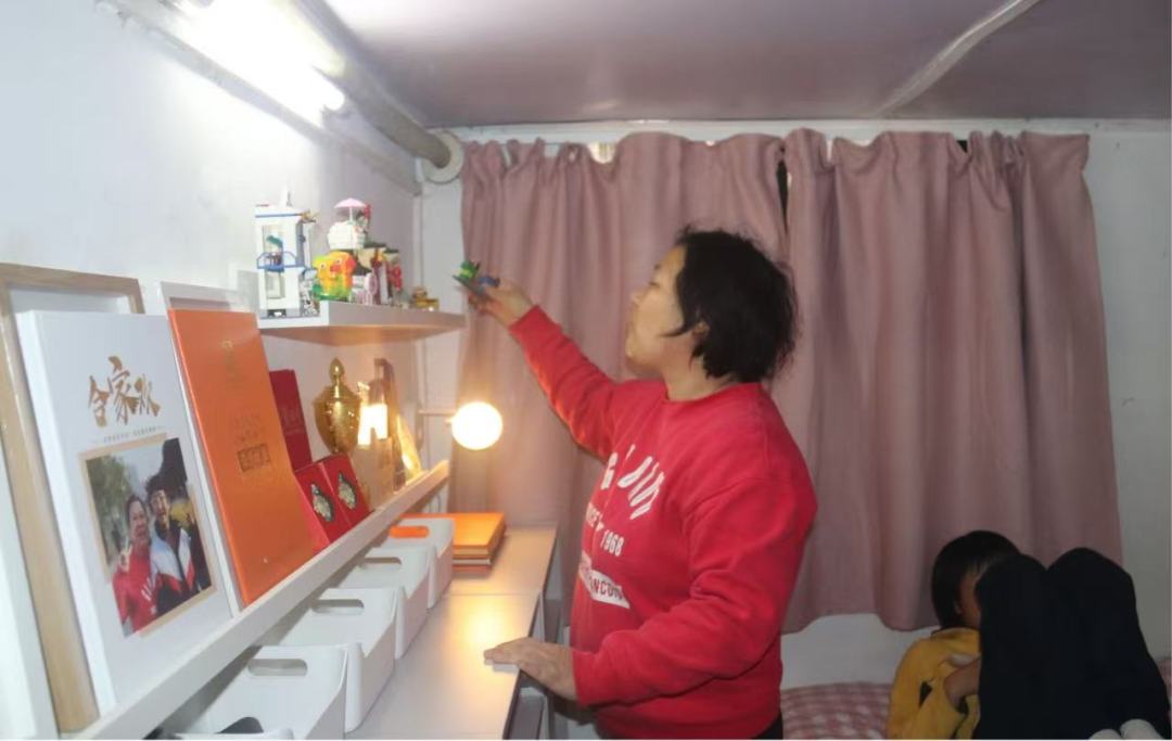 改造后的房间整洁敞亮,小嘉很开心,妈妈拿出小嘉的奖杯和拼好的积木一一摆好。