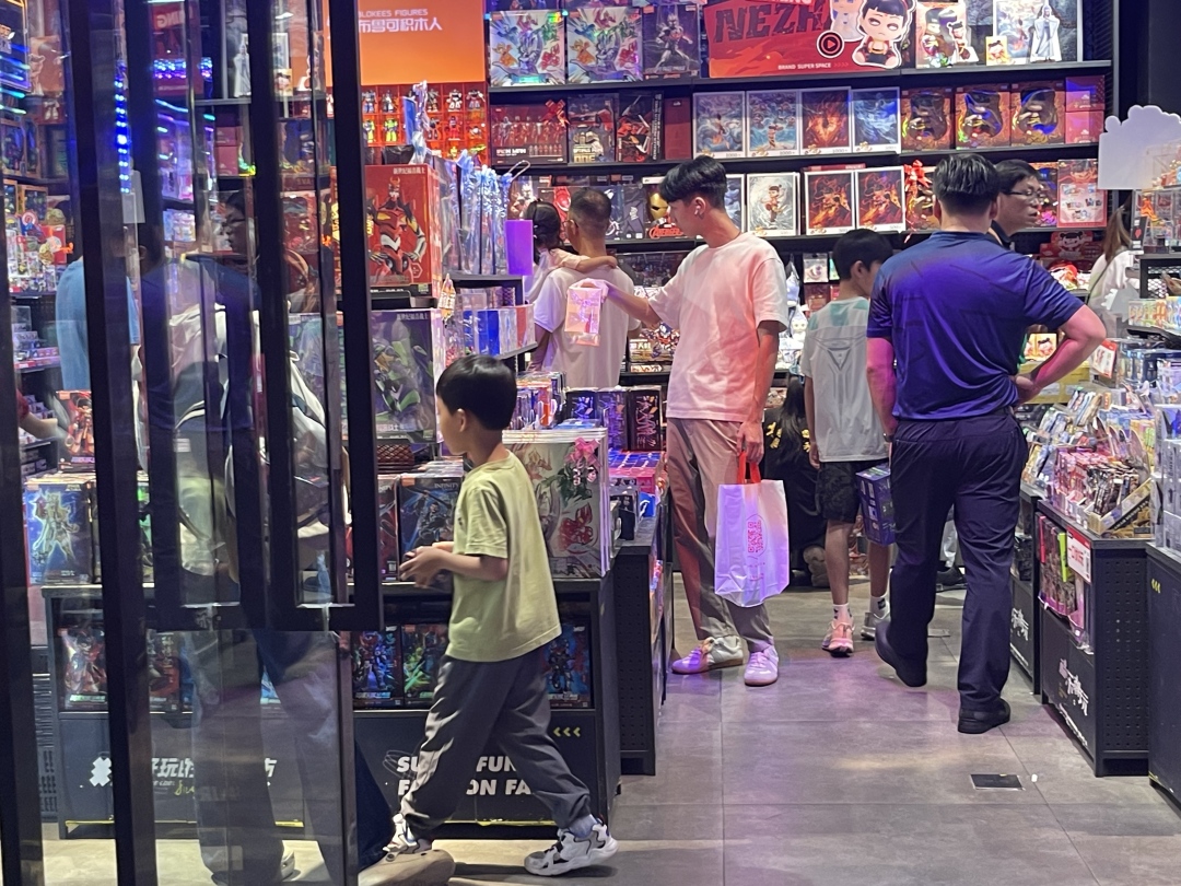 家长带着孩子们在广卡牌店。张柳静摄
