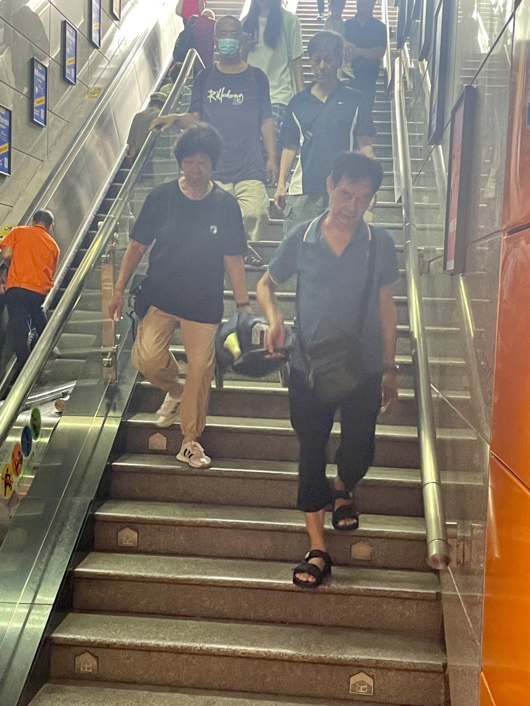 两老抬着买菜小车下楼梯