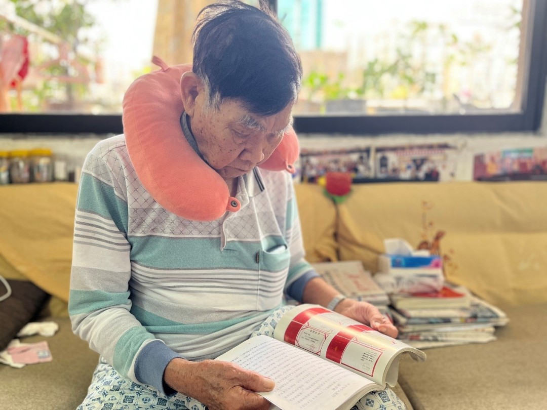 今年89岁的梁卓镇在翻看过去的资料。
