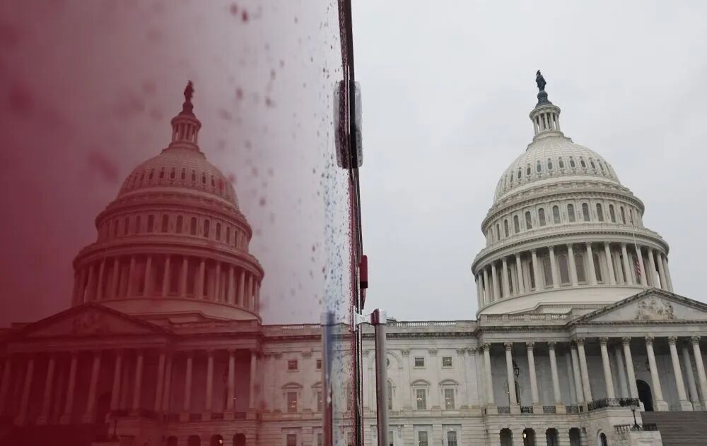 新华社资料图:美国国会大厦映照在一辆汽车上