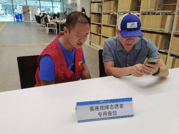 志愿者曲望与冯先生交谈。