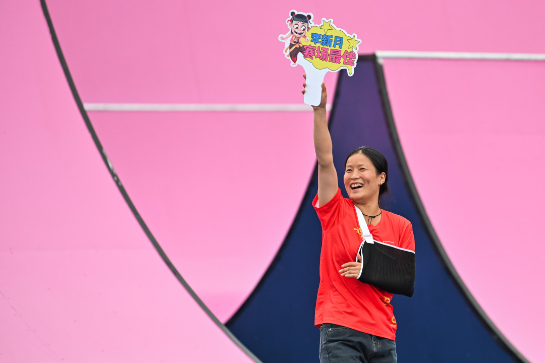 2025年10月24日,第十五届全国运动会自行车(自由式小轮车)比赛在深圳市光明区虹桥公园赛场进行,因手部受伤退赛的安徽代表团选手李欣月,向现场观众展示自己准备的手牌。