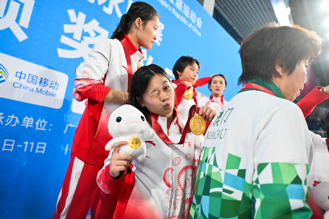 2025年11月2日,广东奥体中心游泳跳水馆,十五运会跳水项目女子团体决赛,夺冠后的全红婵与记者镜头互动。-2