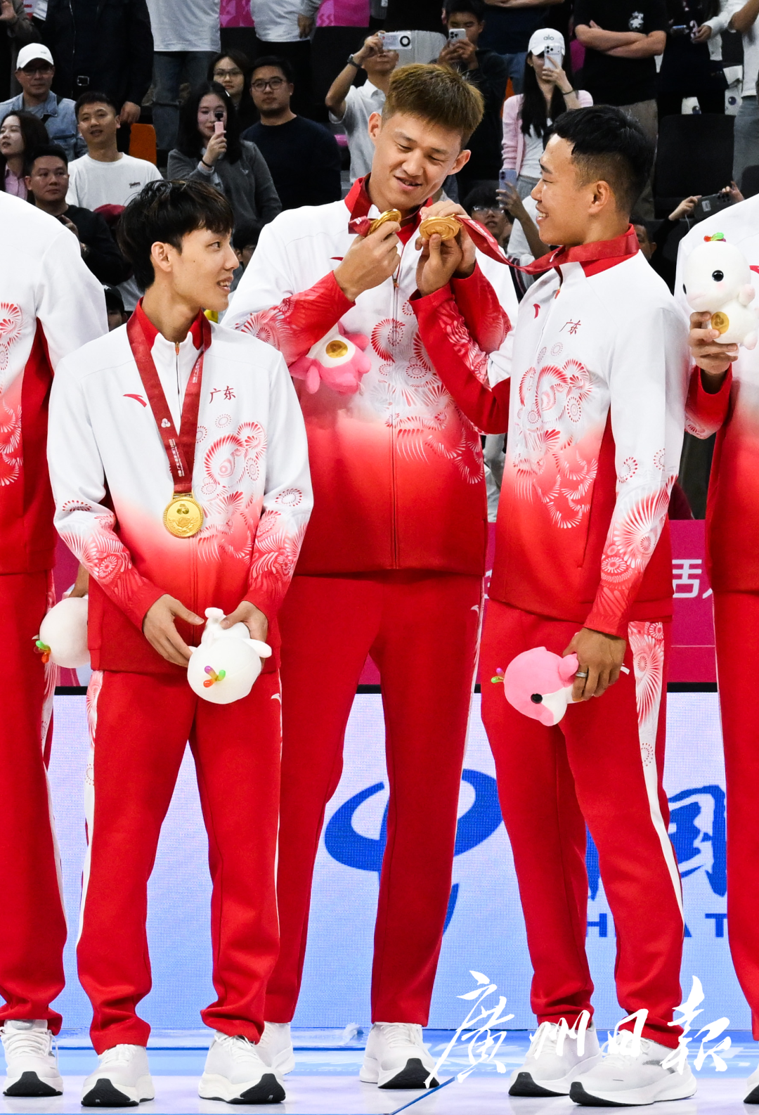 十五运会成年组男篮决赛浙江对阵广东，赛后颁奖仪式上，夺冠的广东男篮队员周鹏（左二）与贺希宁（右一）相互比划金牌。.jpg