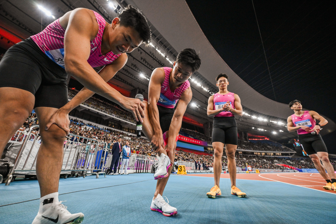 十五运会田径项目男子4乘100米接力决赛,比赛后广东队员苏炳添(左二)脱下战靴。。.jpg 十五运会田径项目男子4乘100米接力决赛,比赛后广东队员苏炳添(左二)脱下战靴。。.jpg