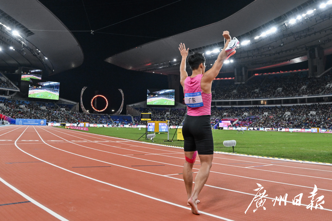 十五运会田径项目男子4乘100米接力决赛,比赛后广东队员苏炳添高举战靴向现场观众告别。-2.jpg 十五运会田径项目男子4乘100米接力决赛,比赛后广东队员苏炳添高举战靴向现场观众告别。-2.jpg