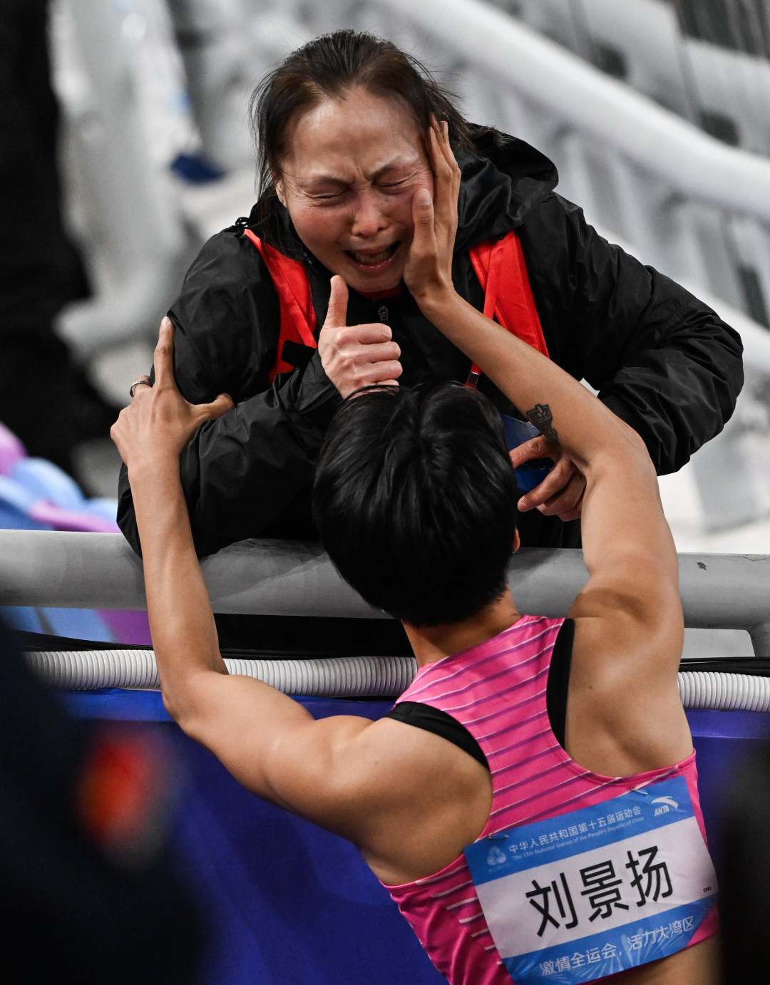 2025年11月19日,广东奥林匹克体育中心,十五运会田径项目女子100米栏决赛,夺冠的广东选手刘景扬与母亲互动。