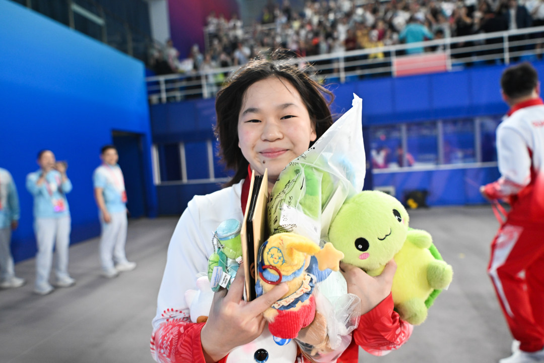 2025年11月2日,广东奥体中心游泳跳水馆,十五运会跳水项目女子团体决赛,夺冠后的全红婵与记者镜头互动。