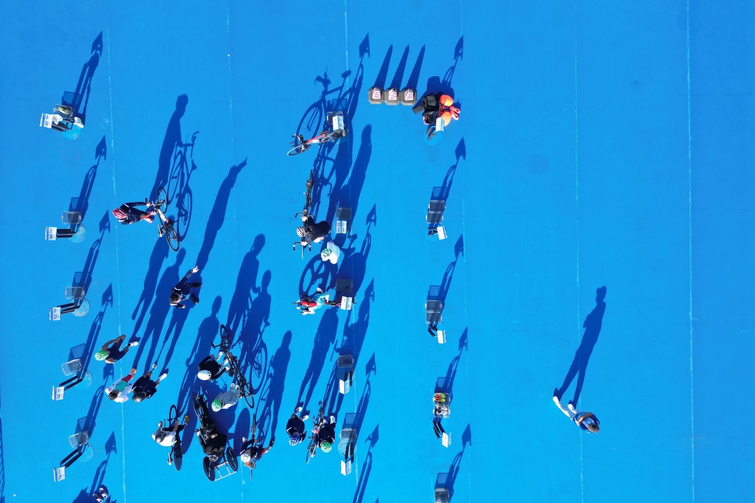 11月26日下午2点至4点,运动员进入赛场进行赛前演练,熟悉比赛路线。图为选手们在游泳上岸后直接进入换项区,准备自行车赛。