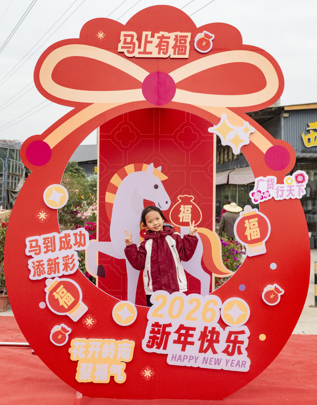 小朋友在喜庆的马年新年布景板前拍照留影。图/广州日报新花城记者:廖雪明