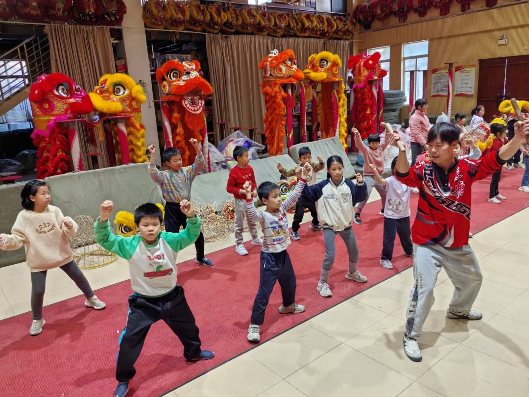 市本级“伙伴计划”爱心托管班(张槎站点)学员们在张槎街道龙狮训练基地学习舞狮。