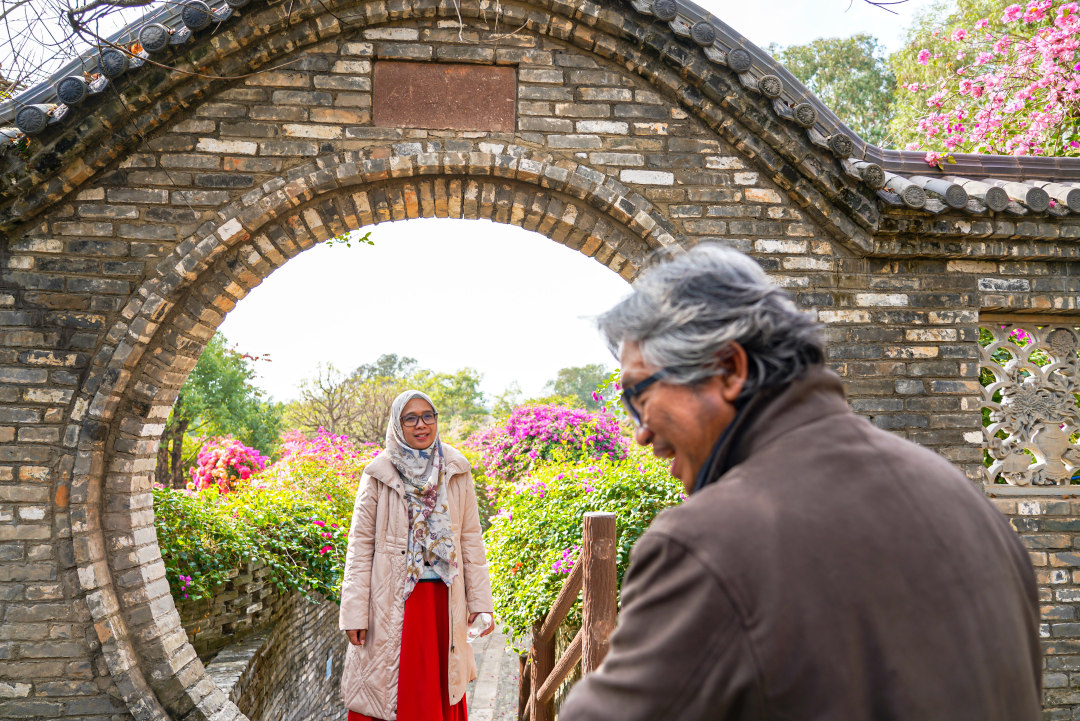 嘉宾站在一处中式圆拱门中与繁花合影。