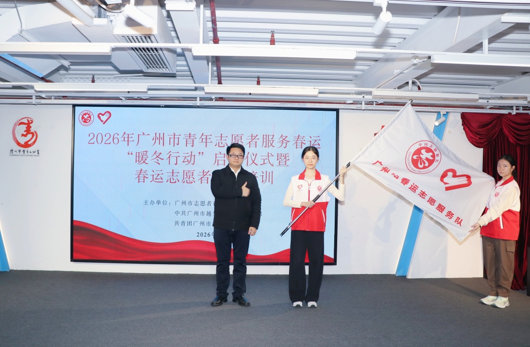 市志愿者行动指导中心相关负责人为2026年广州站春运志愿服务队代表授旗。