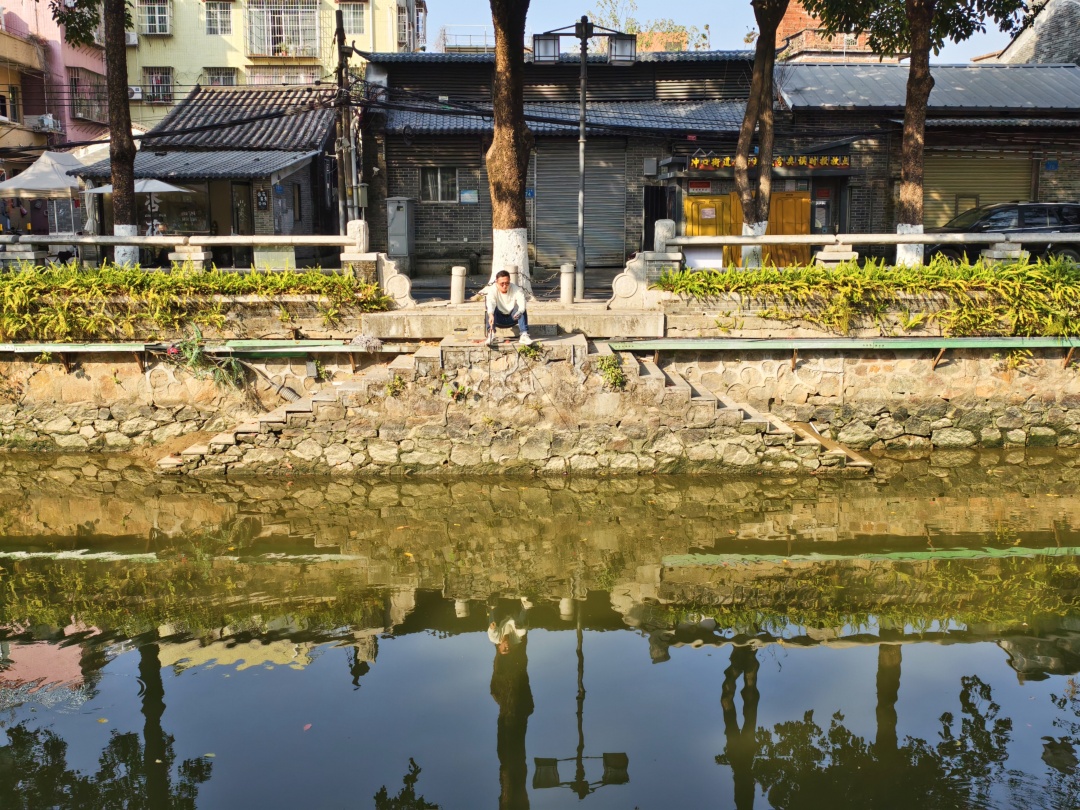 芳村聚龙村前的小河涌,一位市民在阳光下垂钓。