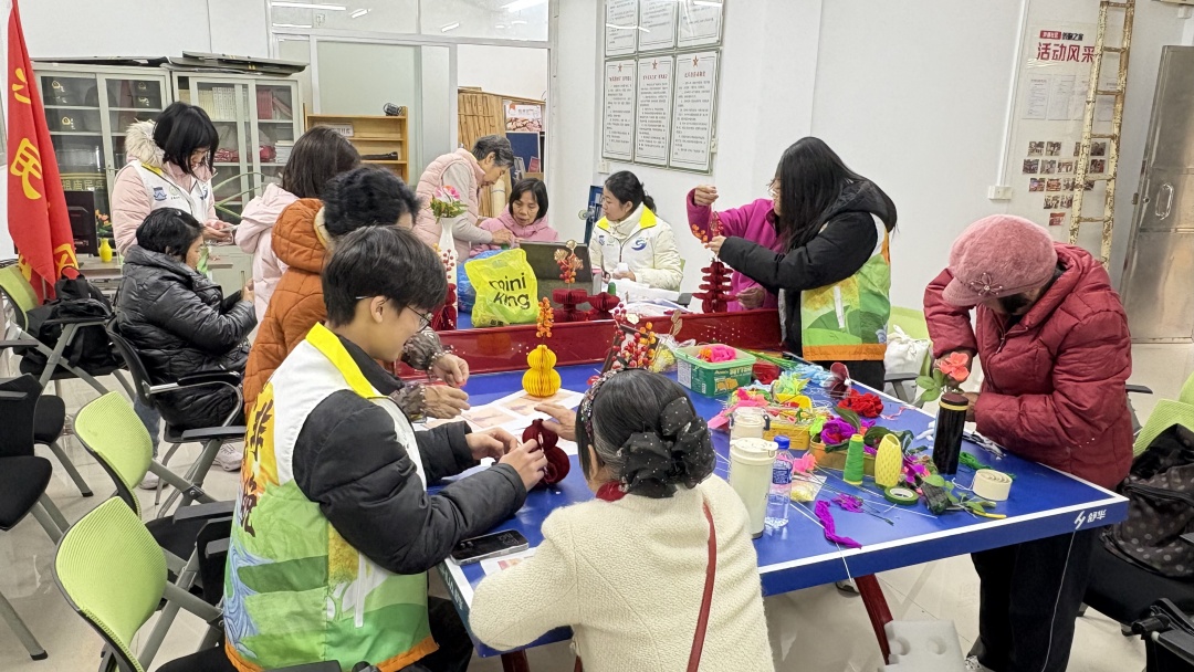 桑榆非晚突击队成员协助佛山市禅城区祖庙街道沙塘社区的老人完成新年花艺制作。