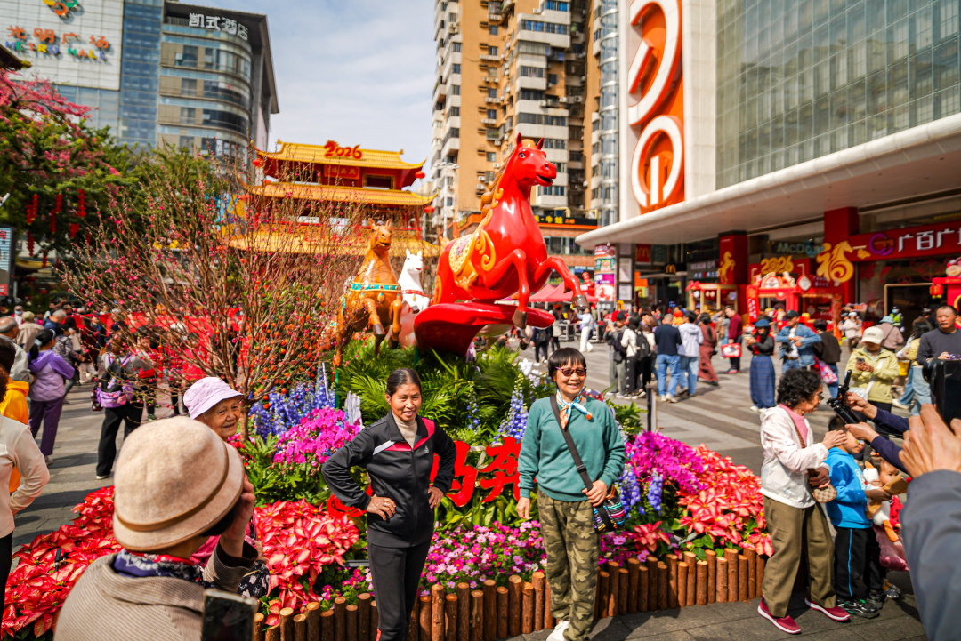 市民游客围着“万马奔腾”主题生肖造型拍照。