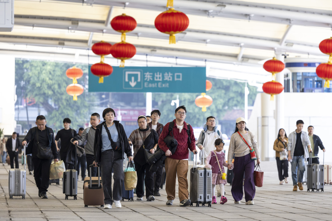 2月13日,广州火车站,旅客拖着行李进站赶车。