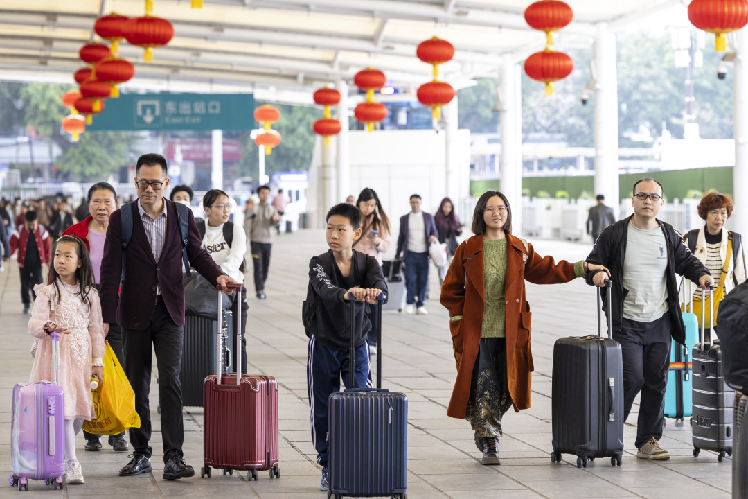 2月13日,广州火车站,旅客拖着行李进站赶车。