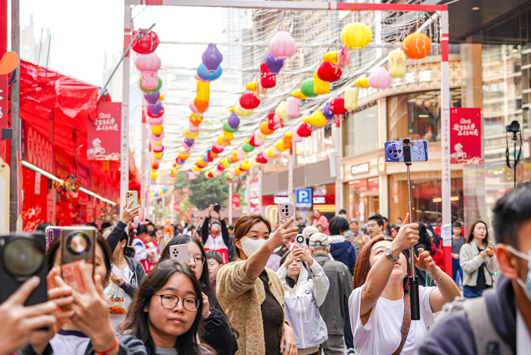 市民游客在越秀西湖花市拍摄热闹场景。