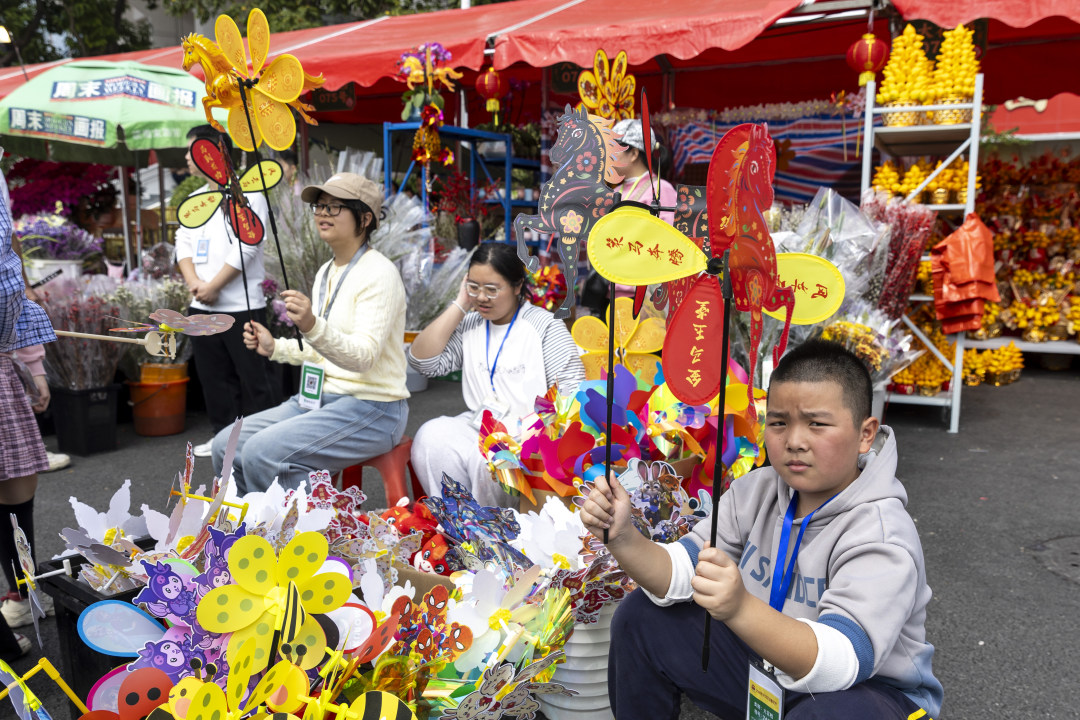 天河花市,小朋友也做起摊主卖风车。