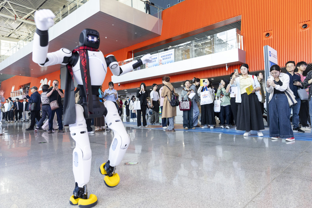“百万英才汇南粤”2026年春季大型综合招聘会现场,不少人围观跳舞的机器人。