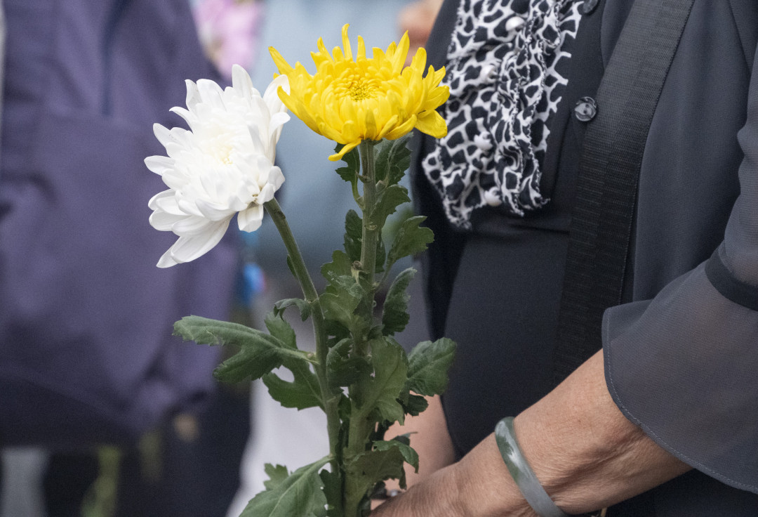参加缅怀活动的遗体捐献者家属手持鲜花。图/广州日报新花城记者:廖雪明