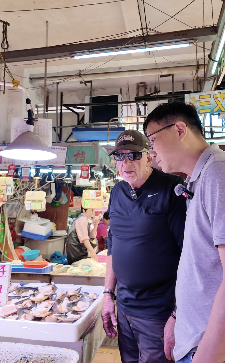 颜生带外国游客逛沙园市场