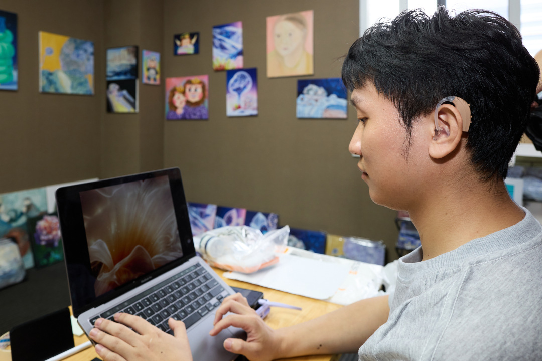 一位听障创业者在电脑上作画