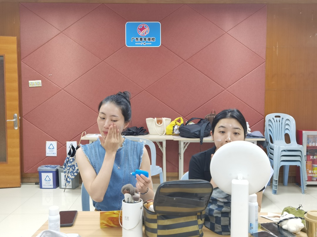 青年夜校学员手持美妆工具细致上妆,以专业技法打造精致妆容,展现悦己青春风采。