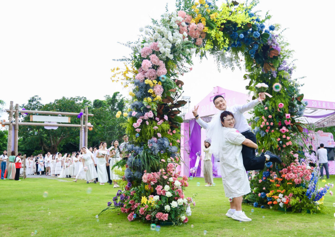 新人洋溢笑容携手穿越“幸福”花门。