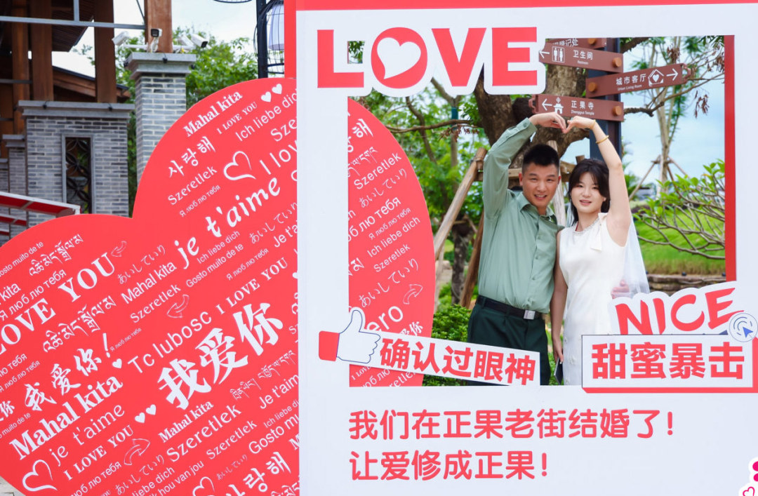 正果老街活动展板前,新人比心合照。