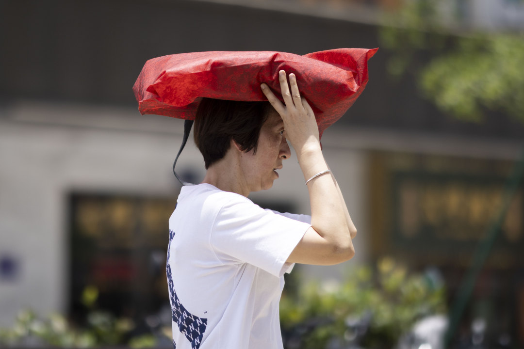 一位市民头顶袋子遮阳。