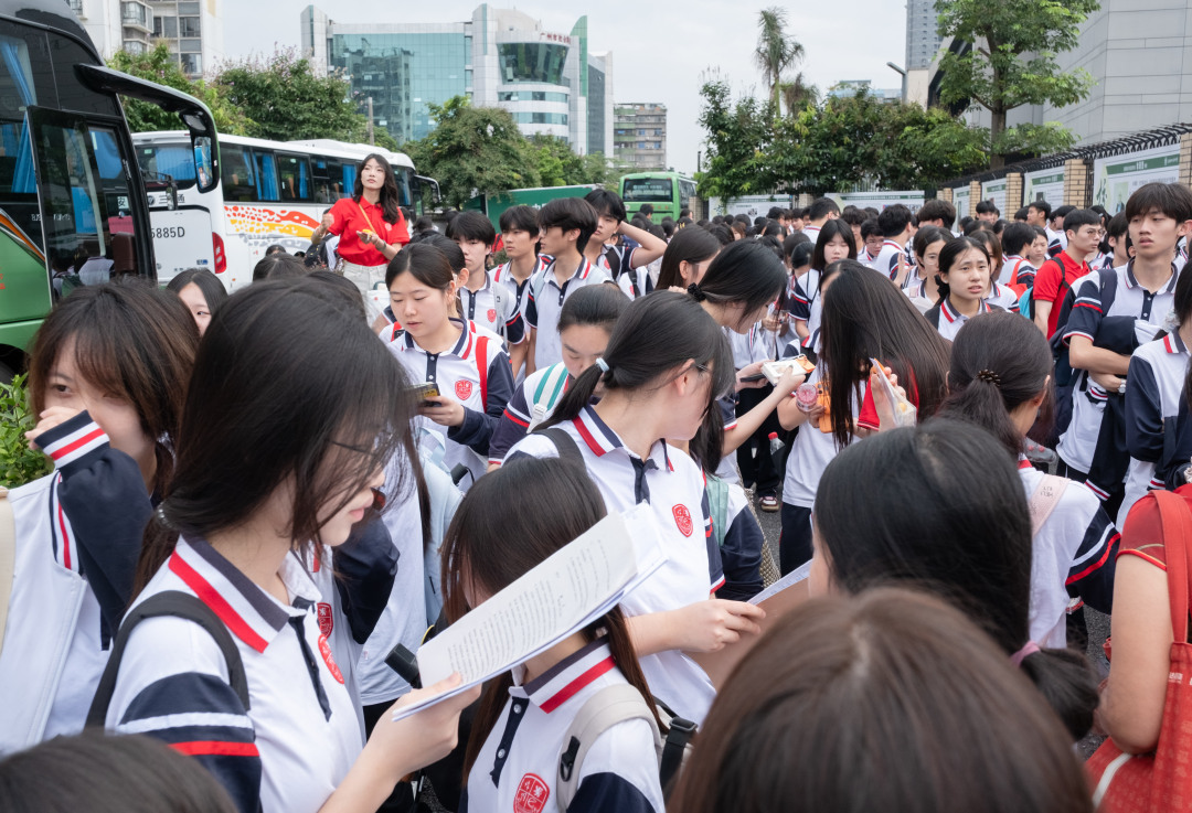 广州市培英中学云城校区考场,广州市亚加达外国语高级中学的考生集体乘坐大巴抵达考场。