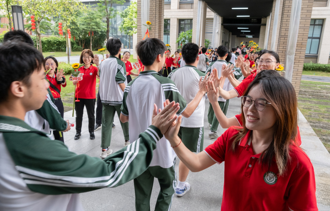 广州市培英中学云城校区考场,老师们人手一支葵花
列队送考,祝福考生“考神附体”“一举夺魁”“旗开得胜”。