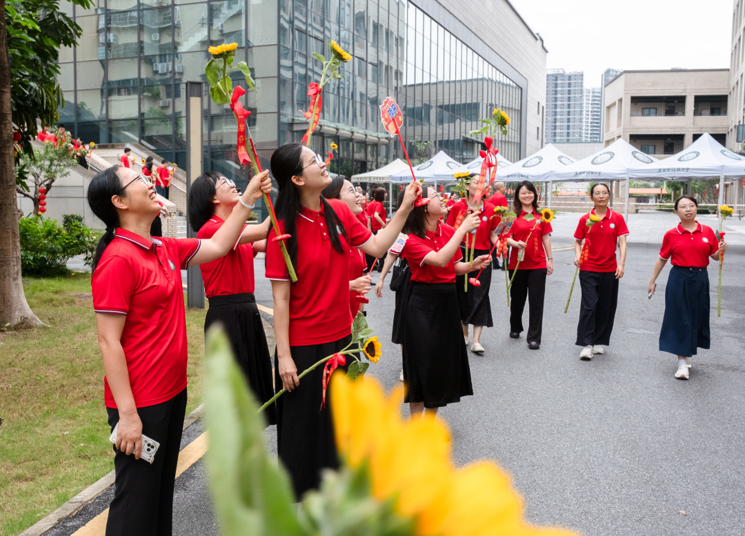 广州市培英中学云城校区考场,广州市培英中学送考的老师们给上楼进考场的考生打气鼓劲。