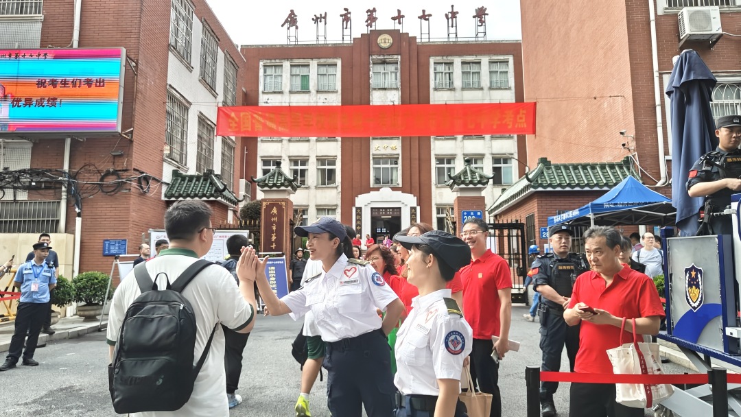 广州市越秀区暐杰志愿服务工作中心青年志愿者在广州市十七中学考点,为入场考生击掌助威、加油鼓劲。
