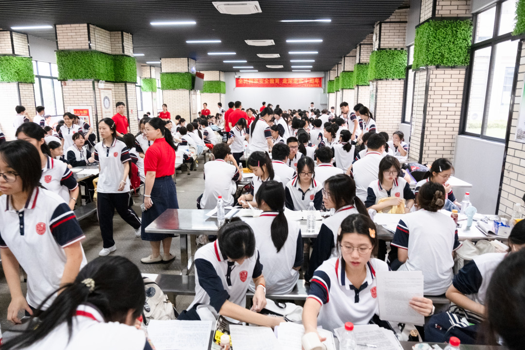 广州市培英中学云城校区考场,广州市亚加达外国语高级中学的考生进考场前集体在广州市培英中学云城校区学生饭堂休息等候。