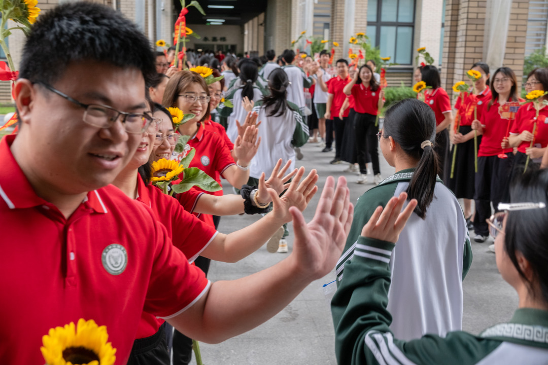 广州市培英中学云城校区考场,老师们人手一支葵花
列队送考,祝福考生“考神附体”“一举夺魁”“旗开得胜”。